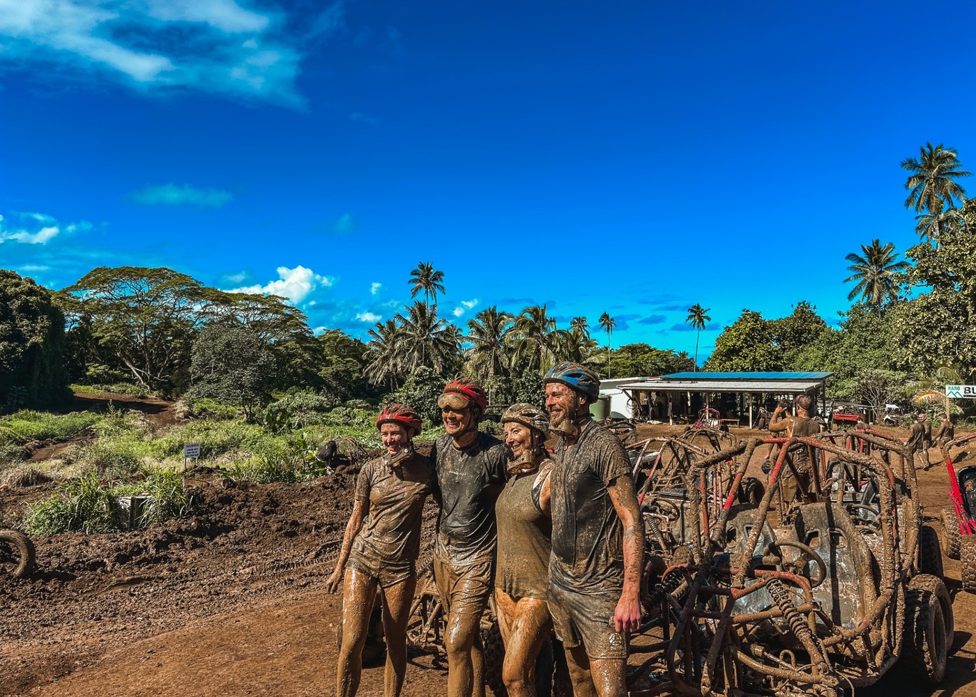 Happy mud-covered guests celebrating after their buggy adventure